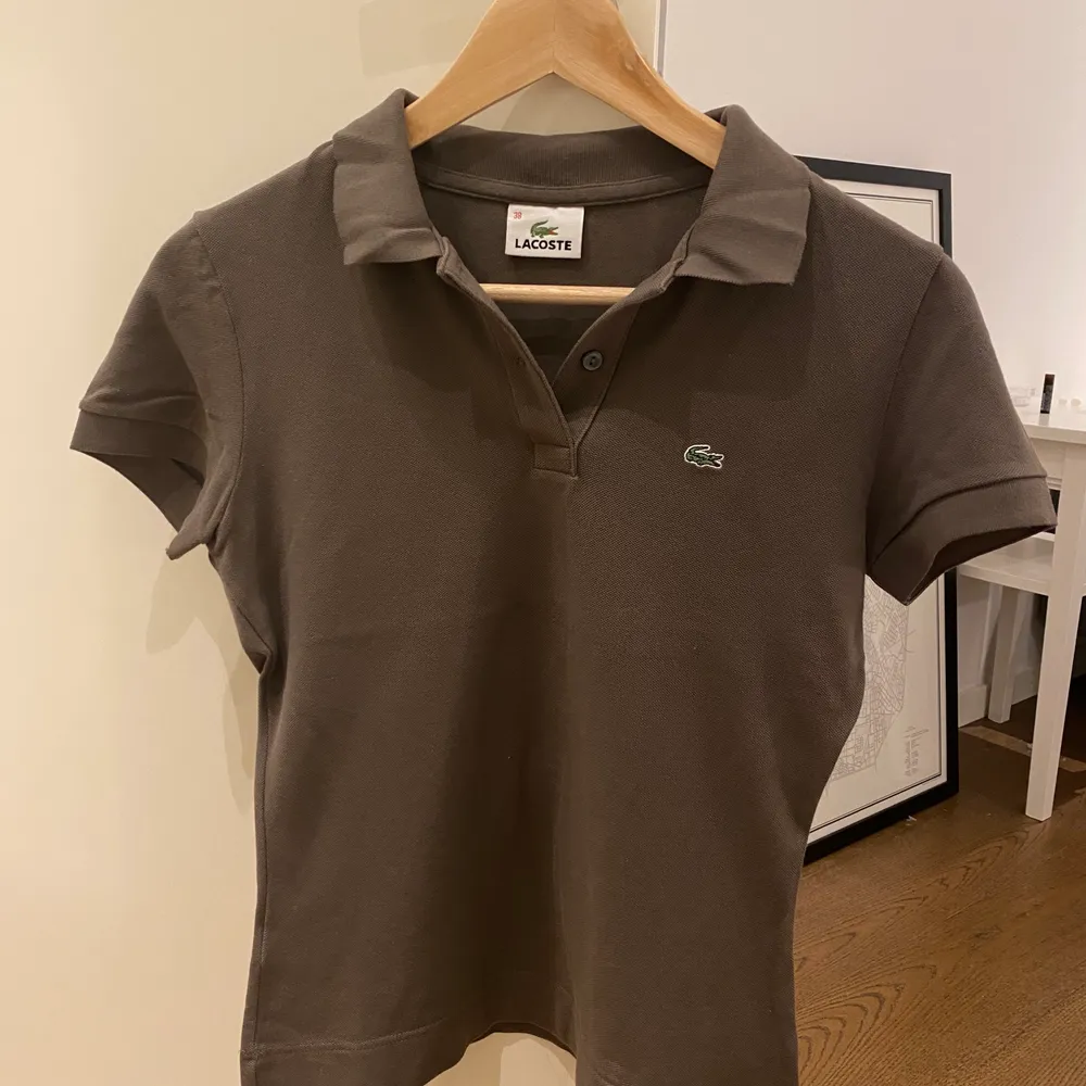 En brun Lacoste tröja för 150 kr.. T-shirts.