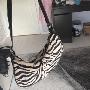 Handväska - Säljer denna zebraväska ifrån Gina tricot, snålt använd och är i väldigt fint skick. Pris kan alltid diskuteras :)