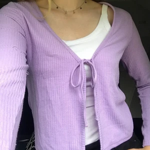 Lila kofta - Lila kofta med knytning från H&M. Storlek M men skulle säga att den är mer som en XS-S i storleken. Den har en liten slitning i form av en liten tråd på ena armen som jag försökt visa på bild 3. Det är inget som direkt märks när man har på sig den. Pris kan diskuteras!