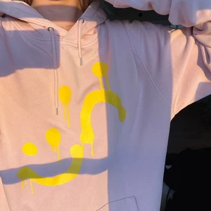 Julie Fagerholt Hoodie - Ljusrosa med gult tryck. Storlek XL men här bärs den av en person med storlek S. 