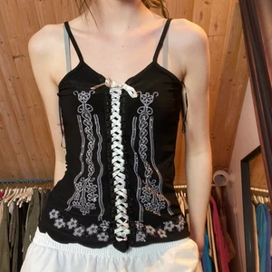 Linne med detaljer - Sött linne med fina detaljer och snörning. Står size XL men skulle säga typ S?