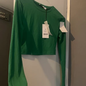 Grön topp - Hög i halsen, strechigt material 