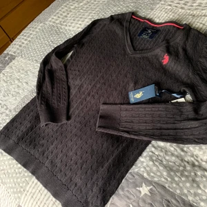 Svart stickad tröja från us polo St L - Super snygg tröja med taggar kvar svart st L  V ringad Märke US polo Aldrig använd tagg kvar inköpt i usa