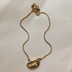 fotlänk snäcka - en guldfärgad fotlänk med metallsnäcka på, frakt 13kr