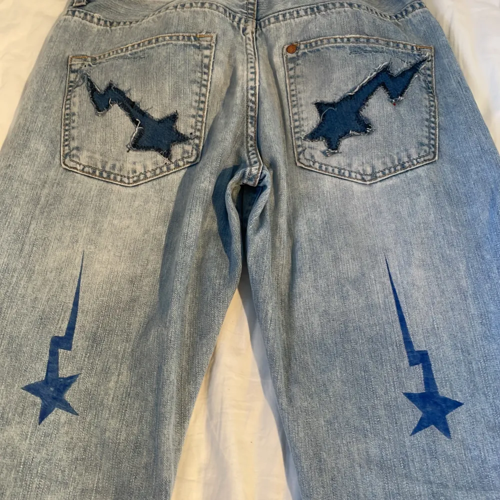 Ett par ljusblåa CUSTOM bape jeans med hål på framsidan !Köparen står för frakten! Low waist/ mid Rise . Jeans & Byxor.