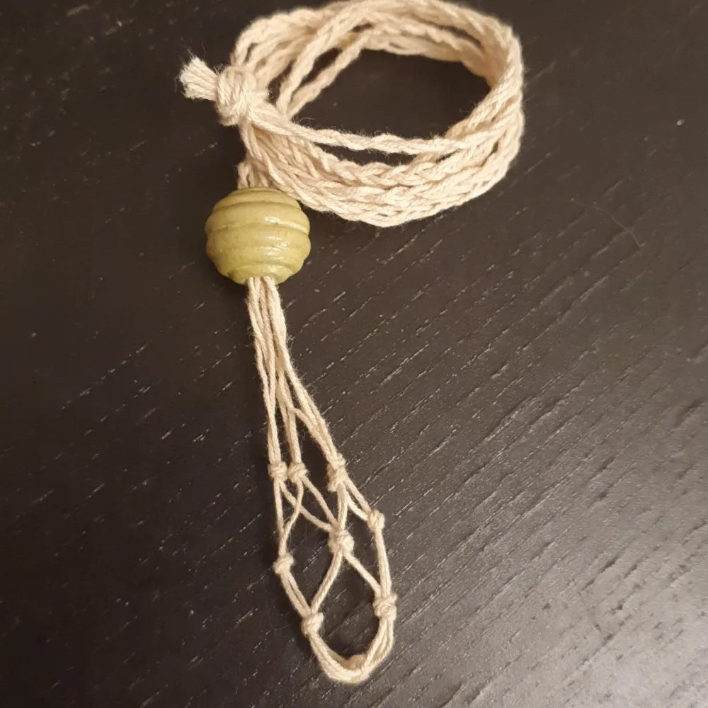Ett halsband till kristaller. KOMMER EJ MED KRISTALL! Ca 72 cm runt halsen. En grön pärla med lite kurvor. Man öppnar genom att skuta upp pärlan.. Accessoarer.