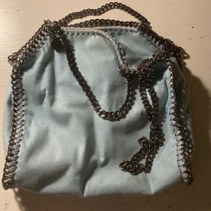 Stella McCartney väska  - Unik ljusblå Stella mccartney väska som passar till allt! Använd ett fåtal gånger, men har en pytteliten liten fläck på sig som säkert går att ta bort💕nypris ligger på ca 9000