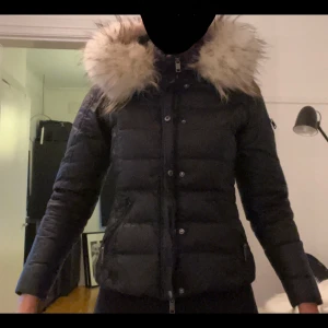 Rock and Blue jacka - Svart Rock and Blue jacka i storlek 38 med äkta avtagbar tvättbjörns päls. Några år gammal och använd några gånger förr men den har bara hängt i garderoben de senaste 3 åren. Inga skador eller repor. Har inte kvar kvittot då jag fick den i present 2018.