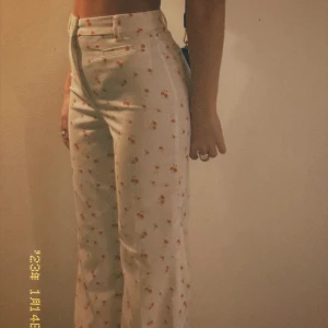 Somriga byxor - Byxor med blommigt motiv från Monki.  Storlek 32.  Säljes då dem inte används längre.  Meddela vid intresse💌