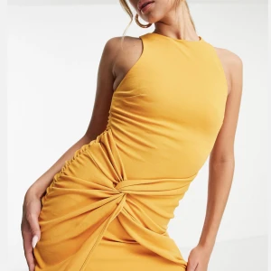 Miniklänning  - Senapsgul miniklänning med hög krage och snurrad omlottdesign