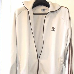 Adidas zip Hoodie - Orginal zip hoddie utan luva. Mycket skön i tunnt material. Tröjan är endast provad och säljes då den aldrig används.                                             Kvalite: Som Ny                           STORLEK: L-XL.                                 Färg: Ljusbeig,                                   Köptes för ca 3 månader sedan för 699:-. Fler bilder kan skickas vid intresse 🌺🛍️📦