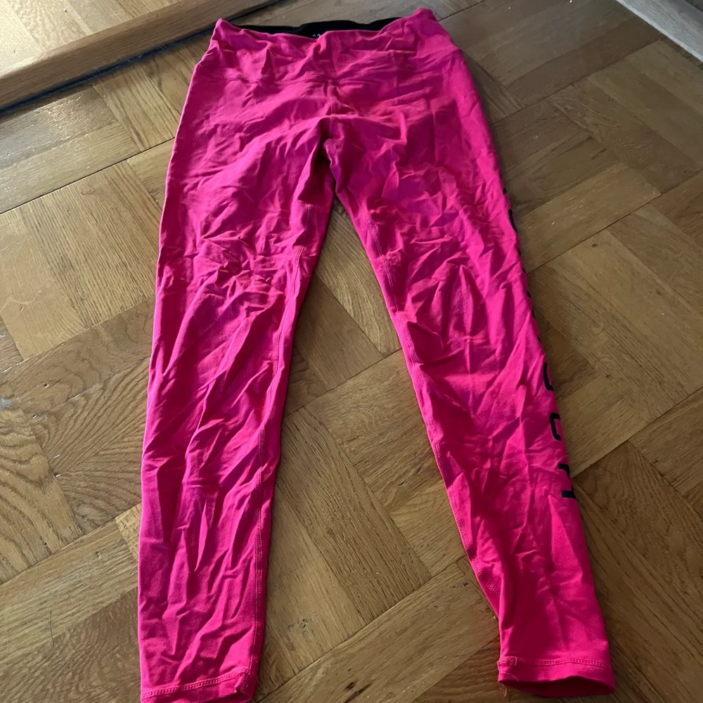 Röd/rosa träningsbyxor från Röhnisch med ficka i midjan på ryggen. Jeans & Byxor.