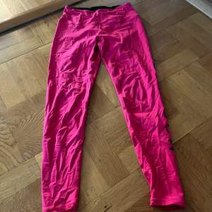 Röd/rosa träningsbyxor från Röhnisch med ficka i midjan på ryggen