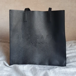 Ted Baker väska - Väska i skinnmaterial (polyester) från märket Ted Baker (socoon) i fint skick. Väskan mäter 35cm på bredden och 60 cm på höjden inkl handtag. Nypris 600kr, jag säljer för 300 kr (+ frakt) ✨️
