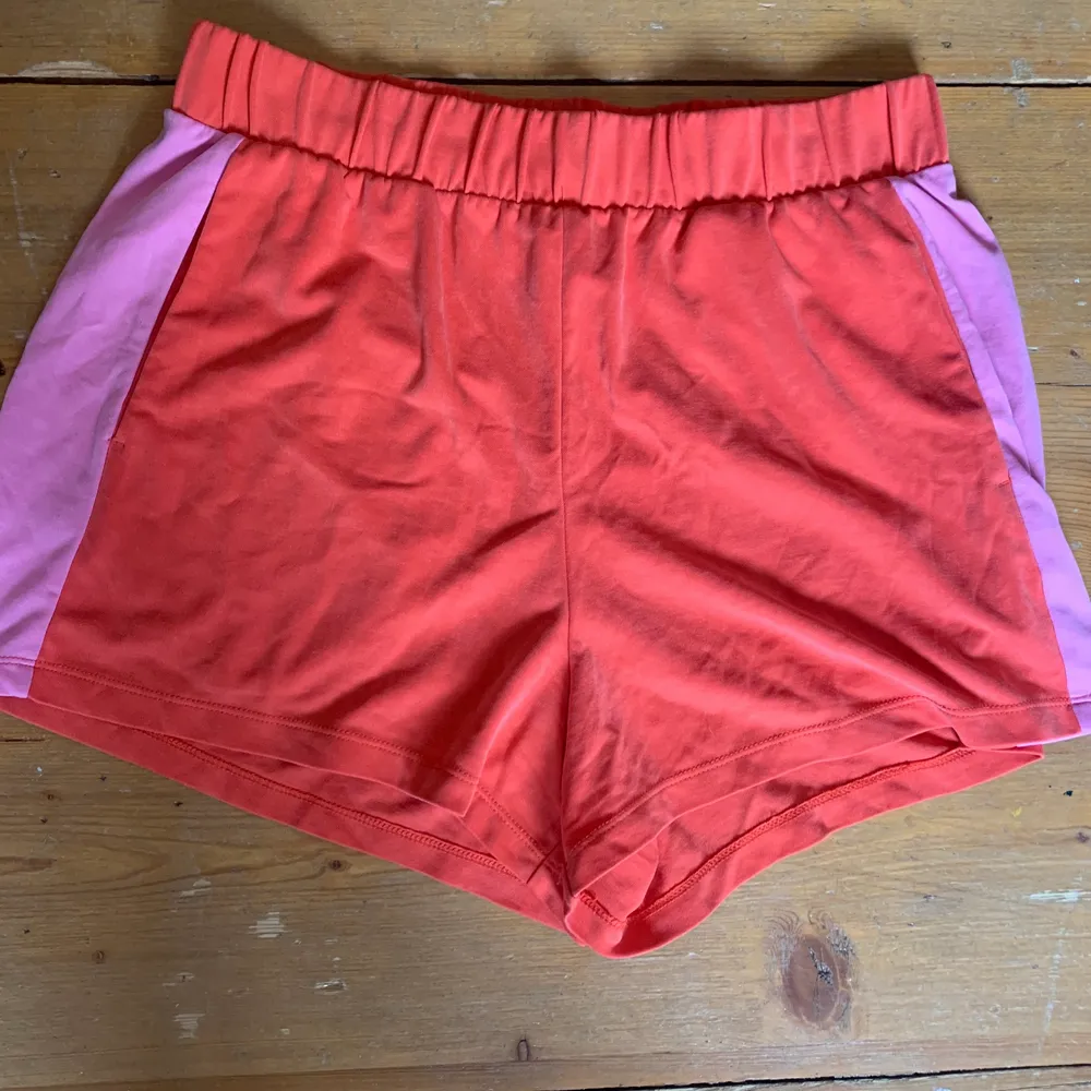 Säljer dessa snygga shorts från monki i rött med rosa revärer på sidorna. Väldigt mjukt material och använt sparsamt. Storlek medium. . Shorts.