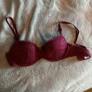 bh hunkemöller  - Drömmig bh i en lite balconette-modell! Gulligaste detaljerna och en fin burgundyfärg, lite lila/röd. Fint skick!! Storlek 70C men skulle säga att den passar en B kupa också. Nypris ca 300kr, säljer för 100kr + frakt, säljer pga för liten🧡