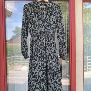 Klänning stl S - Fin grön mönstrad klänning från vero Moda stl S. Slutar mitt på vaden! Finaste färgen! Använd en gång.