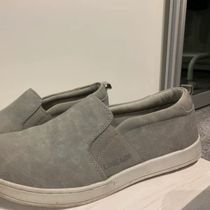 Slip-Ons - Säljer dessa gråa slip-ons som är perfekta för sommaren ifrån märket Linear of sweden. Säljer pågrund av att jag inte använder dem länger, trots använda så är de i ett bra skick.  Köpta för ca 300kr säljer för 99kr