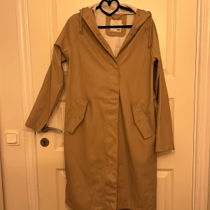 Regnkappa  - Beige regnkappa i storlek xs anvönd 1 gång 