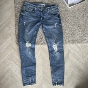 ZARA Skinny Jeans med hål - Ljusblåa ZARA skinny jeans med hål från män-sektionen i affären. Knappt använda, väldigt fint skick. Storlek EUR 42.