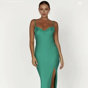 Satinklänning - Säljer denna superfina maxiklänning från Meshki eftersom den tyvärr var för lång för mig. Perfekt till bal/finsittning eller liknande. I nyckick med lapparna kvar. Den heter ” JADE Cowl Neck Backless Maxi Dress - Green” om ni vill se fler bilder. 