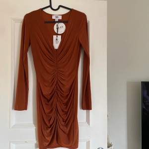 Snygg helt ny klänning från Nakd - kollektion med Rebecca Stella. Aldrig använd, prislapp på. Slät på baksidan. Nypris 699kr.