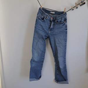 Wide blue jeans with a cool detail of damage on the ends of the legs. Looks cool with almost any t-shirt or crochet sweater. I get a little bit of a 70's feel over these!
