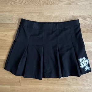 Kjol - Kort kjol med dragkedja och knapp. Perfekt skick, aldrig använd. Coolt vikt.