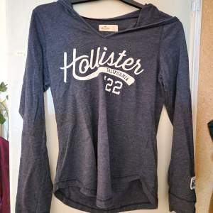 Mörkblå tunn Hollister tröja med luva i storlek S.