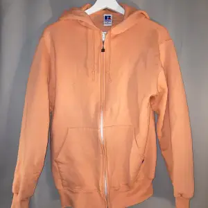 En zip up hoodie från Russell Athletic. Storlek S, 80tals. Väldigt unik persika orange färg 😜 Fri frakt!