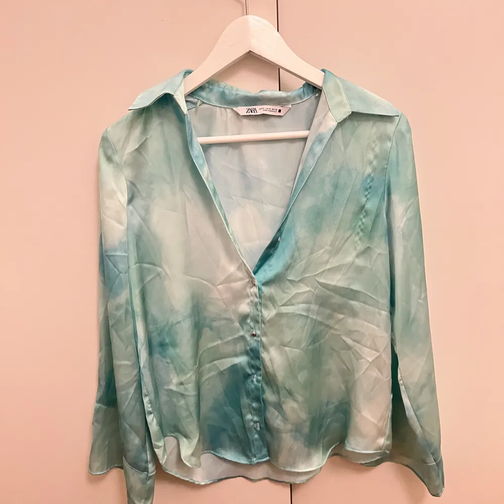 Säljer denna jättefina satin blusen i ett unikt mönster och färg.. Blusar.