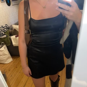 Svart Satinklänning - Säljer min så fina och bekväma satinklänning från Bubbelroom!!! 🤍 Väldigt simpel och enkel att klä upp och ner! Storlek M. Endast använd 2 gånger!!