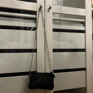 Väska  - Svart väska med nitar från zara. Kommer tyvärr inte till användning längre. Köpt för cirka 250kr. 