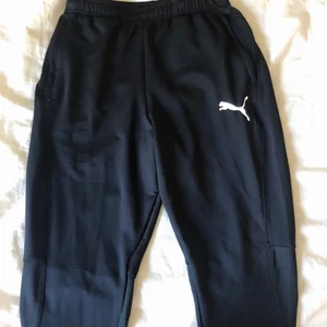 Träningsbyxor - Säljer ett par puma träningsbyxor som aldrig andvänds eftersom de är fel storlek för mig, de har fickor och dragkedjor längst ber på benen. Köparen står för frakt