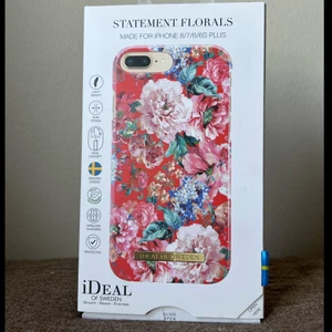 Ideal of Sweden skal  - ”Statement Florals” består av en kombination av pioner och syrener i nyanser av cerise, gammelrosa och blått mot en klarröd bakgrund. Ett riktigt statementskal som genom sina vackra blommor och sin stilsäkra kombination av röda och rosa nyanser garanterat lyfter din stil i sommar. Säljes för 100kr inklusive frakten. 