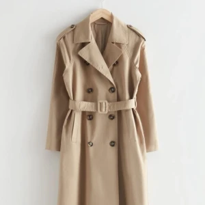 Trenchcoat strl 36 - Oversized trenchcoat från & Other Stories. Den är helt oanvänd med lappen fortfarande på. Nypris var 1450kr.