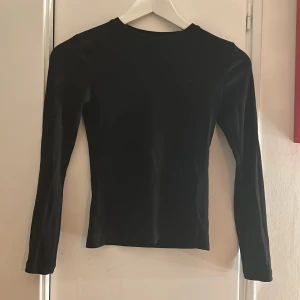 Långärmad tröja - Svart långärmad tröja från Cubus i storlek 140 (barnstorlek) den har en liten slits som man kan se på sista bilden. Använd men inget som syns