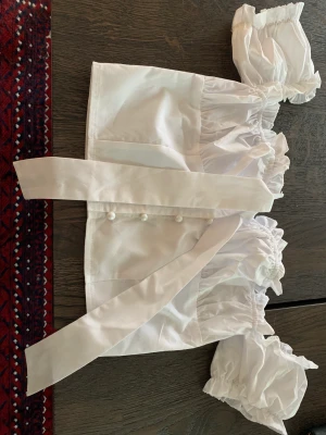 Offshoulder topp med pärlemorknappqr strl 34 - Så fin offshoulder topp med knyt och pärlemorknapoar fr PrettylittleThing. I fint skick. 