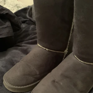 Uggs/ vinter skor  - Ett par gråa fake uggs som ser riktiga ut med tanken på den lilla lappen där bak. Osäkra på storleken men nån stans mellan 37-40. Väldigt varma och bekväma men de har en mjuk sula. ⚠️INTE RIKTIGT ULL! ⚠️ ‼️ 