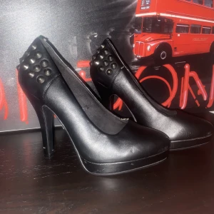 Klackskor - Ett par svarta klackskor med silvriga taggar.