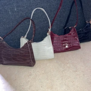 Väska  - Gullig väska i cool färg i krokodilmönster, helt oanvänd!  - väskan är praktisk,  varken för liten eller stor med måtten: bredd 23 cm och längd  16cm. - pris kan diskuteras. 