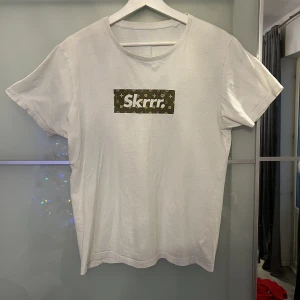 Fancy T-shirt - Säljer denna fancy t-shirt som har en skön look med LV vibes i mitten an t-shirten. Funkar för både kvinnor och män och är i storlek S. Säljes för ynka 99kr.