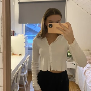 vit kofta - Säljer denna kofta som är kortare i modellen. Ganska väl använd så spår av smink finns på insidan men inget som syns när man har på sig den. Köpt på H&M i storlek S🤍 Köparen står för frakten!