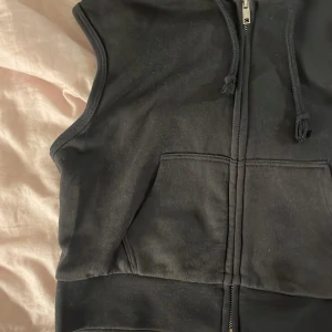 Armlös kofta - En kort armlös kofta från H&M som inte säljs längre. Har haft på mig den vid fåtal tillfällen och det finns inga deffekter. Skicket är som ny. Säljer den för 90 kr :)