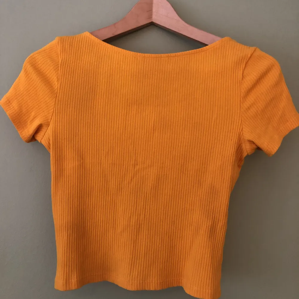 Kort topp i superhärlig brandgul/orange färg, som ny. . T-shirts.