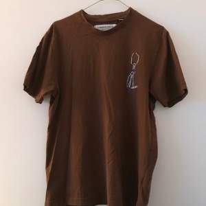 Säljer en t-shirt från det nedlagda märket L’Homme rouge i färgen brun. Size 48/M, sitter lite mindre.