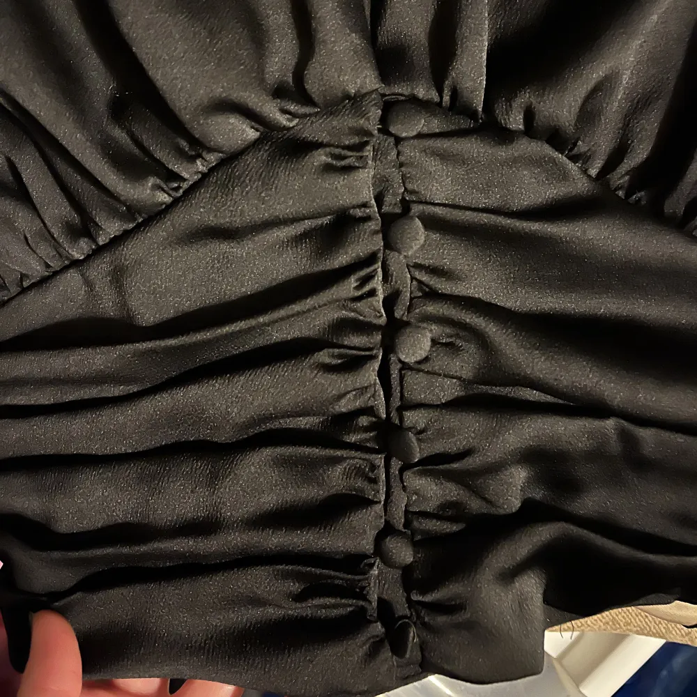 Svart Blus från Gina Tricot i strl XS med svartnar knappar nertil och lite större ärmar nertil (ballongärm).   Fint skick   Material 100% polyester  . Blusar.