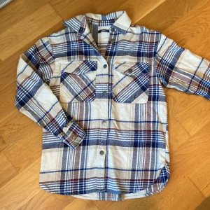 Skjorta - Skjorta i nyskick. Längd fr axel söm är 66cm. Bredd 48 cm. Ärm längd 53cm. 