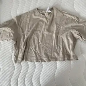 Beige croppad T-shirt från H&M. Oanvänd.  50kr+frakt