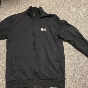 EA7 ZIP TRÖJA - Jag säljer nu min ARMANI Zip tröja. Jag köpte den i somras och har använt den en del. Den köptes för 800 nypris. Den är i bra skick fortfarande och väldigt snygg. Priset går o diskutera.